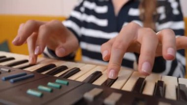 Kadın müzisyen, karmaşık parmak yerleştirmeleri ve antik elektronik sentezleyici enstrümanlarının tuşlarında hassas el hareketleri kaydederek klavye çalma pratiği yapıyor..