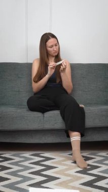 Genç bir kadın evde dinleniyor, doğal tırnaklarını dikkatlice törpülüyor ve şekillendiriyor rahat gri koltukta oturuyor, kişisel güzelliğini ve sağlığını gözler önüne seriyor.