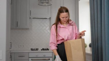 Marketten alışveriş yaptıktan sonra marketten alışveriş yapan bir kadın. Online alışveriş yapan genç memnun olmuş kurye teslimatıyla internetten sipariş edilen ürünlerin paketini açıyor.