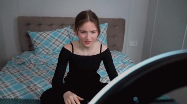 Genç vlogger çocuk kanalı için video blogu yapıyor. Güzellik blogları, teknoloji ve insan konsepti. Yüzük ışığı ve akıllı telefonla evde makyaj yapan mutlu gülümseyen kız blogcu.