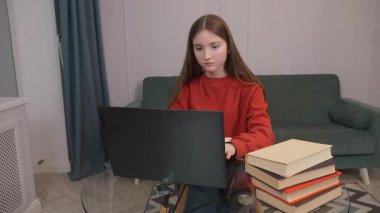 Kitaplarla çevrili mutfak masasındaki dizüstü bilgisayarında ders çalışan ya da işine dalmış genç bir kız. Apartman dairesinde, Kafkasyalı bir kadının internet mağazalarında öğrendiği iş mesafesi.