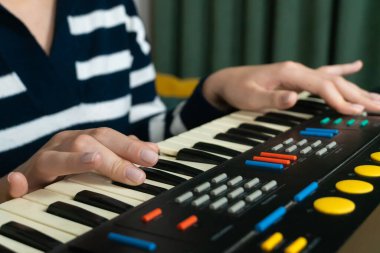 Klasik bir sentezleyici klavye kullanarak elektronik müzik besteleyen bayan müzisyen, nostalji ve sıcak bir ev ortamında retro seslere karşı tutku uyandırıyor.