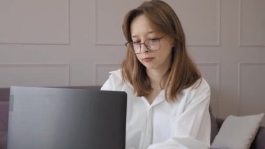 Merkez ofisteki kadın, uzaktan çalışma, fikirler ve düşünme üzerine araştırma yapmak için belgeler ve dizüstü bilgisayar. Masasında bilgisayarla mutlu bir kız, notlar yazıyor ve internette serbest ağ araştırması yapıyor..
