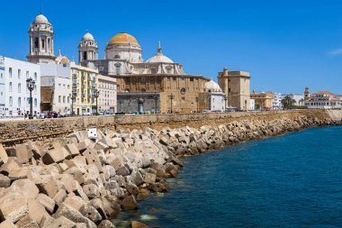 Cadiz seafront promenade with its Catedral de Cadiz and Parroquia de Santa Cruz church. Costa de la Luz, Andalusia, Spain.