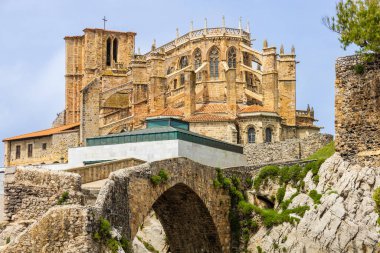 Tarihi taş ortaçağ köprüsü ve Santa Maria de la Asuncion Kilisesi, Gotik ve Romen tarzlarının bir karışımı, yükselen kemerler ve belirgin bir çan kulesi. Castro-Urdiales, Cantabria, İspanya.