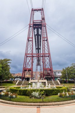Bir çeşme ve Vizcaya Köprüsü sütunuyla Plaza Puente, Portekiz ve Bask Bölgesi, İspanya 'daki Getxo kasabalarını birbirine bağlayan dünyanın en eski ışınlayıcı köprüsü..