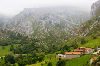 Liebana bölgesindeki Bejes kasabası Picos de Europa dağları ve bulutlarıyla çevrilidir. Cantabria, İspanya.