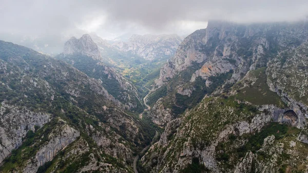 Dar La Hermida geçidine, içinden geçen dolambaçlı yola ve bulutlu bir günde Santa Catalina bakış açısı olarak da bilinen Jozarcu bakış açısıyla Picos de Europa 'nın engebeli tepelerine bakmak. Cantabria, İspanya.