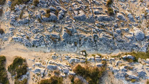 Erozyon sonucu oluşan tuhaf şekilli kumtaşı kayaların gökyüzü görüntüsü. Virgen del Mar Adası, Cantabria, İspanya.