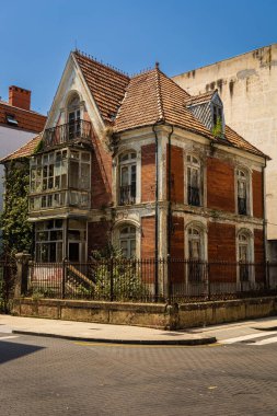 Şehir merkezinde iki katlı terk edilmiş eski bir ev, geleneksel tarzda, balkonları, kırmızı kiremitli çatısı ve sarmaşıkla kaplı. Santona, Cantabria, İspanya.