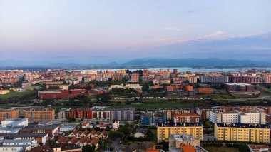 Santander şehrinin havadan görünüşü, sokakları, yolları, evleri ve uzaktaki dağları. Gün batımı. Santander, Cantabria, İspanya.
