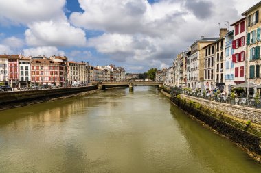 Nive nehrinin manzarası ve şehir merkezinde renkli panjurlar bulunan geleneksel eski Fransız evleri. Bayonne, Pirenes-Atlantik, Fransa.