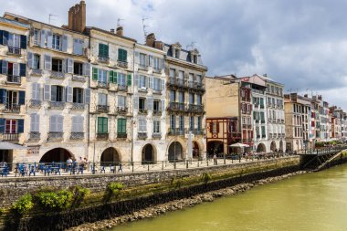 Renkli panjurları, Nive nehri ve seti olan geleneksel eski Fransız evleri manzarası. Bayonne, Pirenes-Atlantik, Fransa.