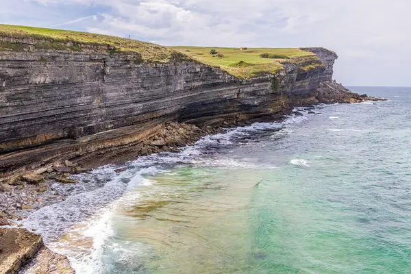 Atlantik Okyanusu ve Cantabrian kıyıları, Punta de la Rebollera, yatay tortul jeolojik katmanlarıyla. Cantabria, İspanya.