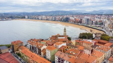 Gijon 'un eski tarihi merkezinin havadan görünüşü, Playa de San Lorenzo plajı, gezinti güvertesi, körfez, şehir manzarası ve çevresindeki dağları içerir. Gijon, Asturias, İspanya.