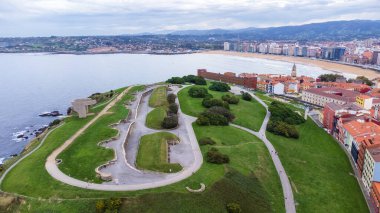 Yeşil parkı, tarihi merkezi, körfezi, şehri ve uzak dağlarıyla Santa Catalina yarımadasının havadan görünüşü. Gijon, Asturias, İspanya.