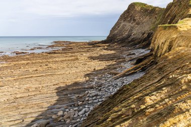 Kaya oluşum katmanları, uçurumlar ve uzaktaki Atlantik Okyanusu. Sakoneta Flysch, Deba, Gipuzkoa, Bask Ülkesi, İspanya.
