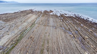 Atlantik Okyanusu 'na giren katmanlı kaya oluşumlarının hava görüntüsü. Sakoneta Flysch, Deba, Gipuzkoa, Bask Ülkesi, İspanya.