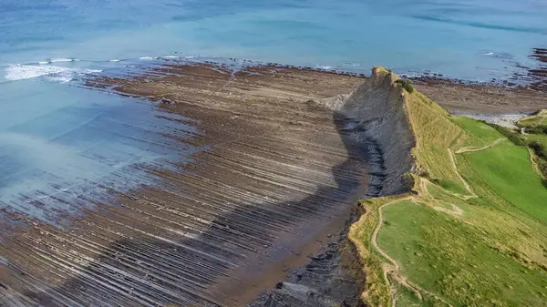 stock image Aerial view of flysch, the Atlantic Ocean, cliffs, and green meadows. Sakoneta Flysch, Deba, Gipuzkoa, Basque Country, Spain.