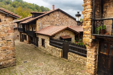 Verandalı, ahşap kaplamalı ve kırmızı kiremitli çatıları olan iki katlı, dar kaldırımlı evler. Barcena Belediye Başkanı, Cantabria, İspanya.