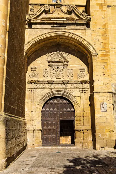 stock image Main entrance to the Majestic Church of the Assumption, yellow stone building with arches, decorated with sculpture. Briones, La Rioja, Spain.