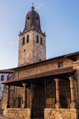 The Church of Saint Martin (Iglesia de San Martn). Historic church made of ashlar, rubble and masonry, baroque in style, with an impressive modernist style bell tower featuring an ashlar roof. Cabezon de la Sal, Cantabria, Spain. clipart