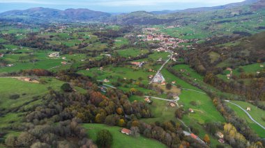 Aerial view of the green Pasiegos Valleys and the villages of Llera and Selaya, surrounded by mountains. Mirador de La Braguia II, Cantabria, Spain. clipart