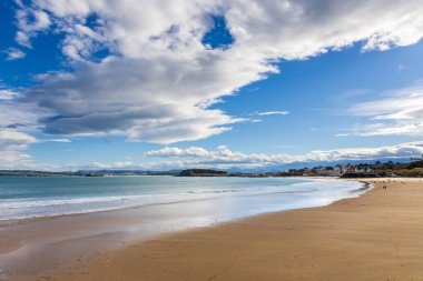 Sardinero II kumlu plajı, kısmen güneşli bir gökyüzü altında, Atlantik, dağlar ve şehirle birlikte uzak mesafelere kadar uzanır. Santander, Cantabria, İspanya.