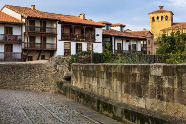 Ana caddelerden birinde kırmızı kiremitli çatıları ve ahşap balkonları olan geleneksel beyaz evler. Santillana del Mar, Cantabria, İspanya.