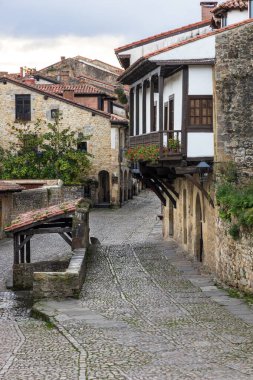 Calle del Rio 'da geleneksel evlerle çevrili Ortaçağ çeşmesi ve çamaşırhanesi (Fuente Lavadero-Abrevadero). Santillana del Mar, Cantabria, İspanya.