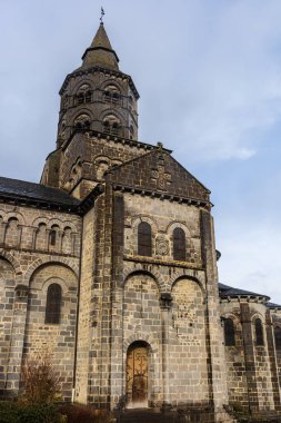 Orcival Meryem Ana Bazilikası 'nın kesik kolu ve çan kulesi Parc des Volcan d' Auvergne 'deki ortaçağ Romanesk kilisesi. Orcival, Auvergne-Rhone-Alpes, Fransa.