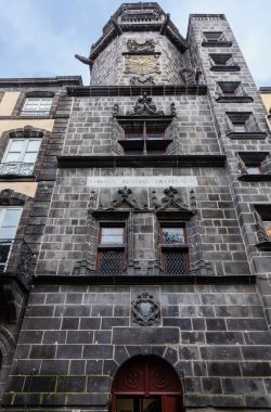 Riom veya Saat Kulesi, Gotik ve Rönesans sekizgen kulesinin saat yüzlü koyu volkanik taştan yapılmış yakın görüntüsü. Riom, Puy-de-Dome, Auvergne-Rhone-Alpes, Fransa.