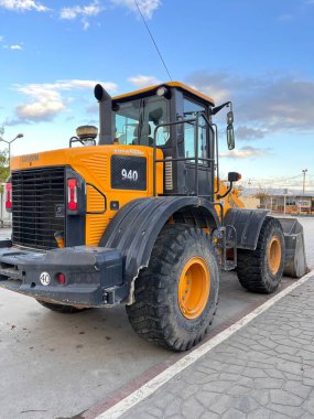 Mavi bulutlu gökyüzünde traktörle çakıl yolda buldozer..