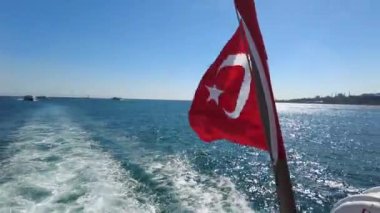 Travel sailing by tourist ship in the Golden Horn, Istanbul, Turkey. he Turkish flag flutters in close-up