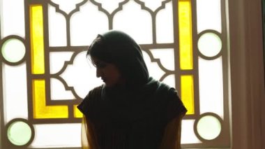 Türbanlı ve tesettürlü Müslüman kadın camide elleri havada dua ediyor. Din dua kavramı.