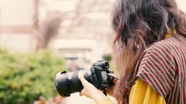Genç Arap turist kadın tesettür takıyor, şehri gezerken kamera kullanıyor.