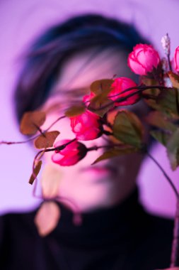 Stüdyoda çiçeklerle poz veren yüksek model kadın. 