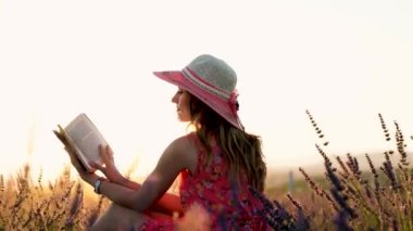 Lavanta bahçesinde kitap okuyan genç bir kadın..
