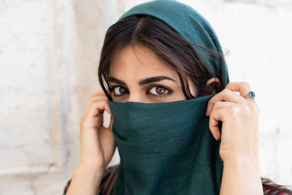 Açık havada gülümseyen Müslüman kadının portresi.