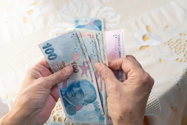 Hands holding Turkish Lira banknotes
