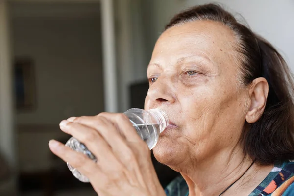 Close-Up Portrait Of A Elderly Woman Drinking Water