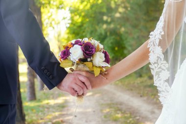 Gelin ve damat gelin buketi taşıyor.