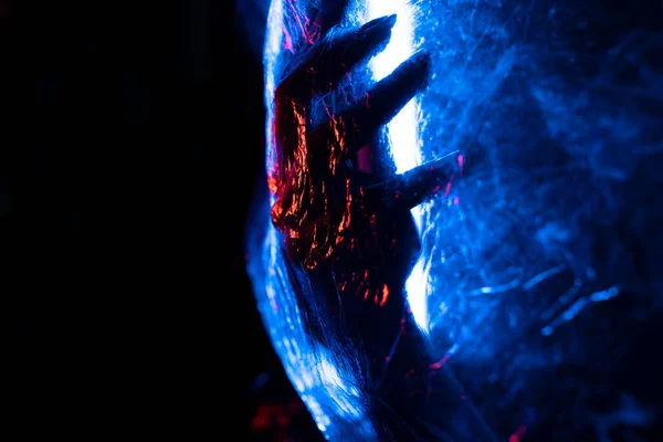 stock image Arm of woman pressing against curtain. silhouette woman behind blue light poses mysteriously and artistically