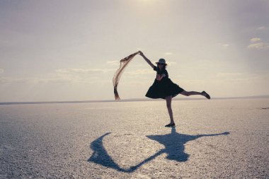 gün batımında sahilde yürüyen genç bir kadın