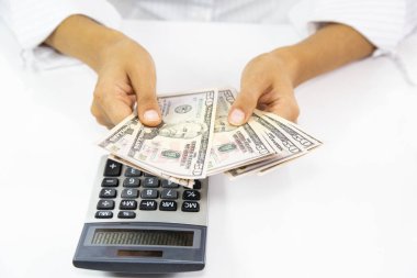 Hesap makinesi ve yığınla banknot kullanarak kadının elini yakın plan çek.