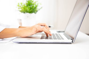 Dizüstü bilgisayarı ve kalemi olan kadın elleri 