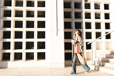 Sokakta akıllı telefondan konuşan genç bir kadın.