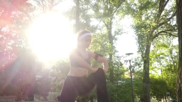 Νεαρή Γυναίκα Που Εκτείνεται Πριν Από Ένα Τρέξιμο Στο Πάρκο — Αρχείο Βίντεο