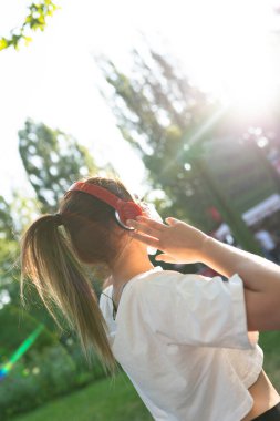 Yüzü maskeli genç bir kadın parkta koşuyor.