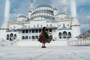 Cami önünde dans eden mutlu Müslüman kadın.